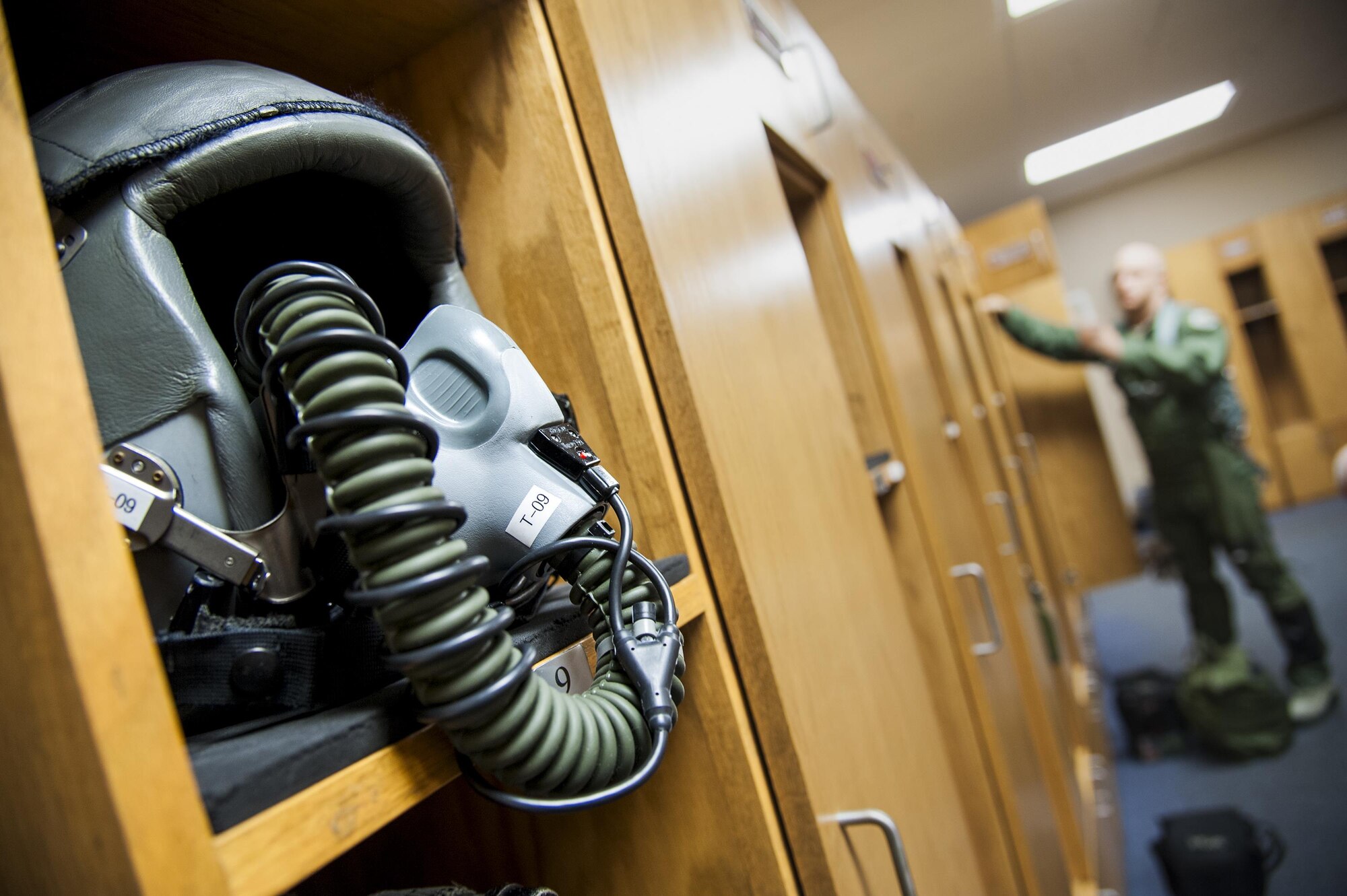 A pilot’s helmet sits on a shelf while U.S. Air Force Maj. Jeremiah Parvin, 23d Wing chief of safety and A-10 Thunderbolt II attack aircraft pilot, gathers his gear in preparation for flight, Feb. 18, 2016, at Moody Air Force Base, Ga. Multiple U.S. Air Force aircraft within Air Combat Command conducted joint aerial training at Grand Bay Bombing and Gunnery Range. During the training, the aircraft conducted tactical air and ground maneuvers, as well as weapons training. (U.S. Air Force photo by Andrea Jenkins/Released)