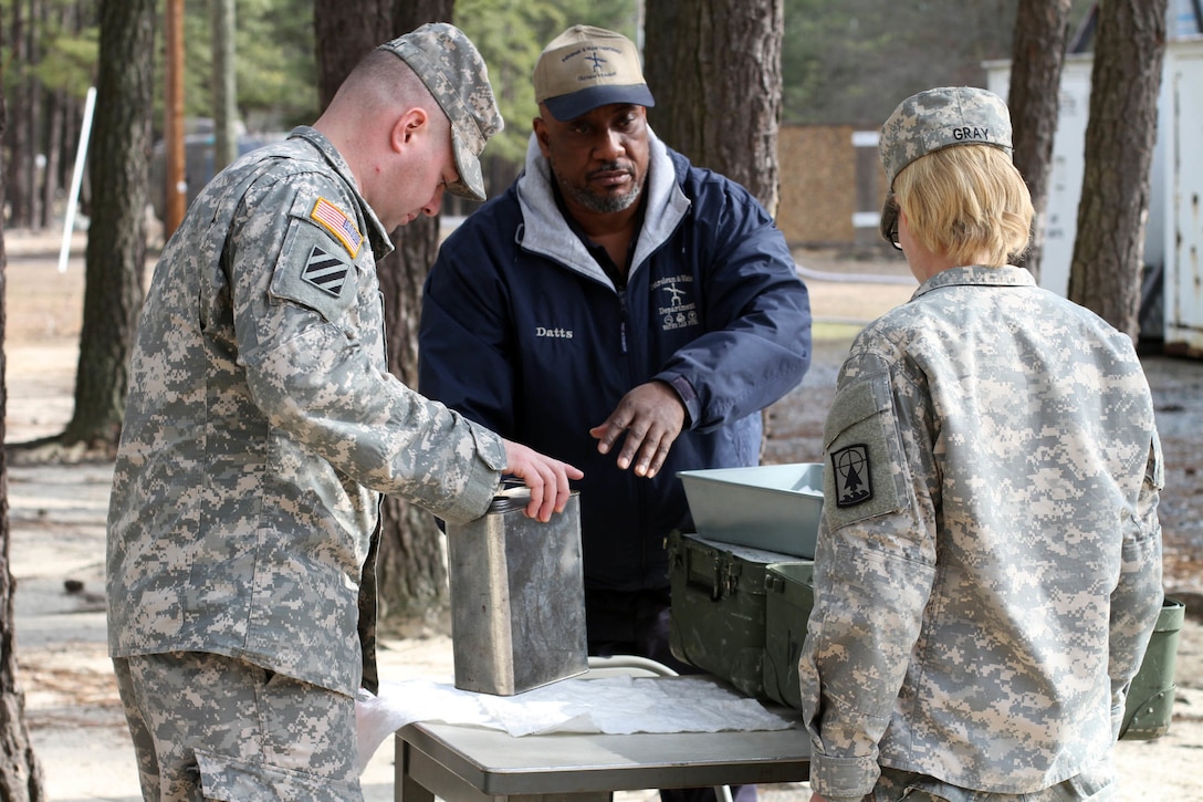 Russell Datts, civilian contractor and instructor at the 94th Training Division's Petroleum Supply Specialist Reclassification Course, provides guidance and instruction on fuel testing techniques in the field at Fort Lee, Va.