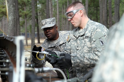 During a field training exercise for the Petroleum Supply Specialist Reclassification Course at Fort Lee, Va., Sgt. 1st Class Torron Williams, an instructor assigned to the 94thTraining Division, provides guidance to one of his students, Sgt. Taylor Broschart of the 947th Quartermaster Company out of Chambersburg, Penn.