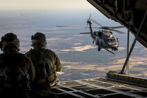 U.S. Air Force Senior Airman Kevin O’Neil, left, and Tech. Sgt. Christopher Reynolds, 71st Rescue Squadron loadmasters, signal to an HH-60G Pave Hawk from the back of an HC-130J Combat King II during aerial refueling operations, Feb. 18, 2016, in the skies over Moody Air Force Base, Ga.  Multiple U.S. Air Force aircraft within Air Combat Command conducted joint aerial training at Grand Bay Bombing and Gunnery Range. During the training, the aircraft conducted tactical air and ground maneuvers, as well as weapons training. (U.S. Air Force photo by Senior Airman Ryan Callaghan/Released)