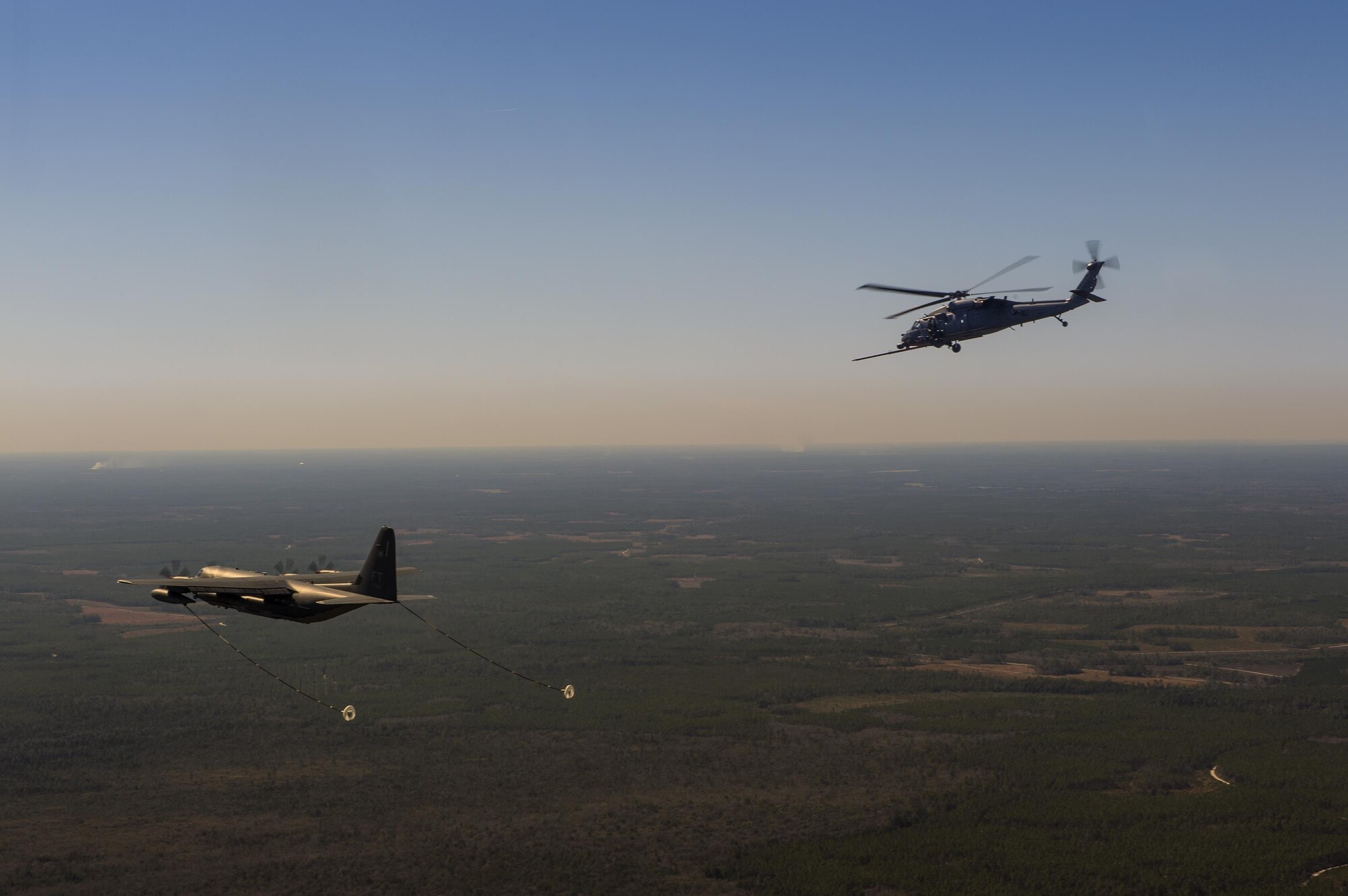 An HH-60G Pave Hawk from the 41st Rescue Squadron flies towards an HC-130J Combat King II from the 71st RQS during aerial refueling operations, Feb. 18, 2016, in the skies over Moody Air Force Base, Ga.   Multiple U.S. Air Force aircraft within Air Combat Command conducted joint aerial training at Grand Bay Bombing and Gunnery Range. During the training, the aircraft conducted tactical air and ground maneuvers, as well as weapons training. (U.S. Air Force photo by Senior Airman Ryan Callaghan/Released)