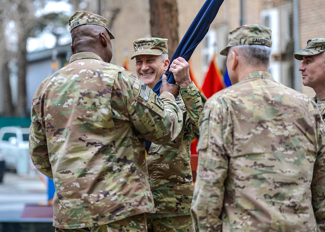 Army Gen. Lloyd J. Austin III, left, commander of U.S. Central Command, passes the colors to Army Gen. John W. Nicholson Jr., center left, incoming commander of U.S. Forces Afghanistan and NATO’s Resolute Support Mission, during a change-of-command ceremony in Kabul, Afghanistan, March 2, 2016. Army Gen. John F. Campbell, center right, the outgoing commander, and Army Command Sgt. Maj. Delbert Byers, right, look on during the ceremony. Air Force photo by Staff Sgt. Tony Coronado