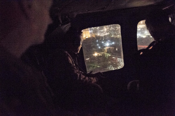 Marine Corps Gen. Joseph F. Dunford Jr., chairman of the Joint Chiefs of Staff, left of window, looks at Kabul, Afghanistan, March 1, 2016, while flying on a UH-60 Blackhawk helicopter. DoD photo by D. Myles Cullen
