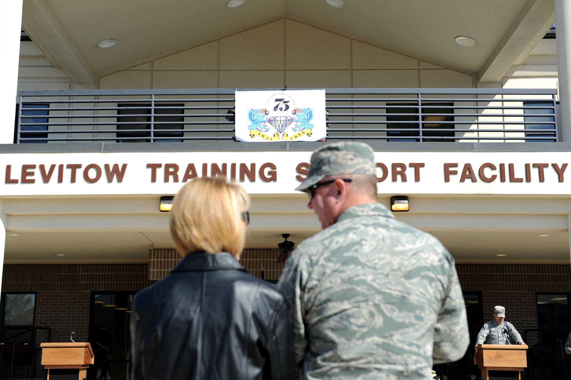 Col. Scott Solomon, 81st Training Group commander, and his wife, Devalynn, react to the unveiling of Keesler's 75th anniversary logo during the 81st TRG's quarterly drill down competition at the Levitow Training Support Facility drill pad, Feb. 26, 2016, Keesler Air Force Base, Miss. Base leadership, 81st TRG students, the U.S. Air Force Honor Guard Drill Team and community representatives helped kick off the yearlong celebration of activities and events to celebrate Keesler's 75 years of training and community involvement. 