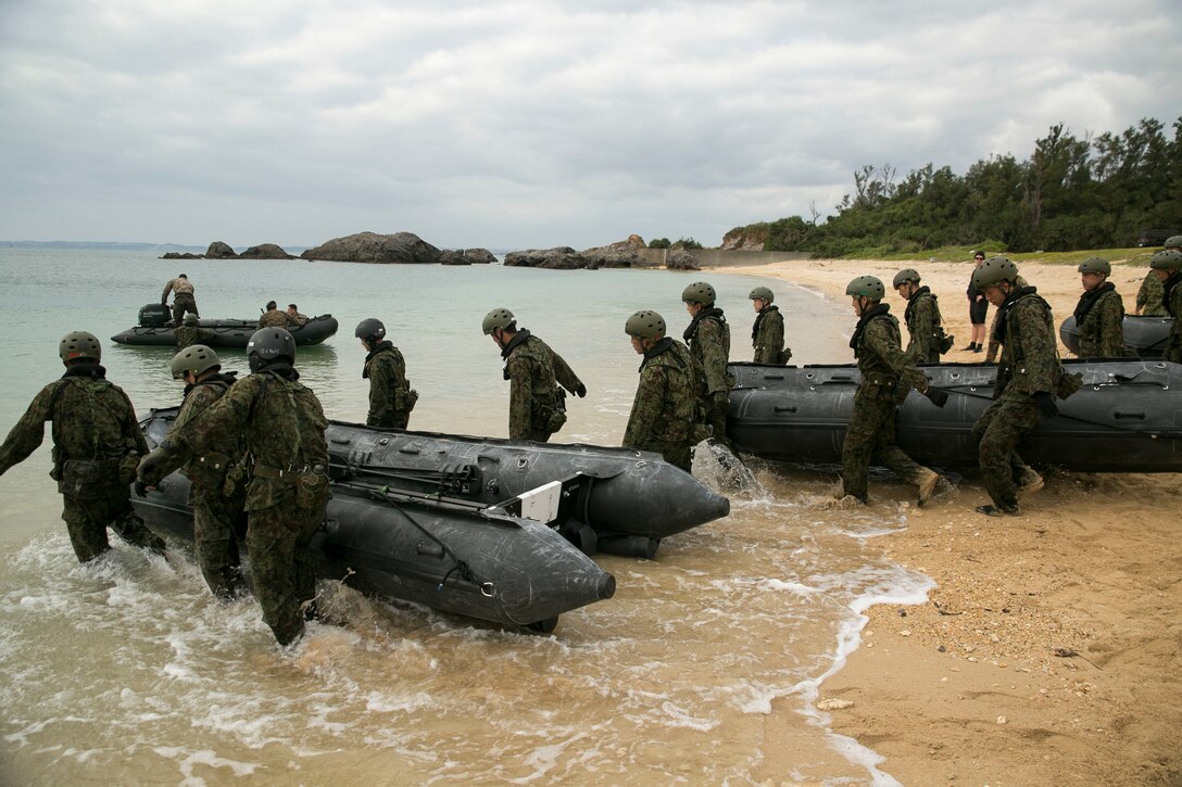 Service members with the Japan Ground Self-Defense Force pull Combat Rubber Raiding Craft into the water at Kin Blue, Okinawa, Japan, March 1. The JGSDF members observed Marines from 3rd Reconnaissance Battalion, 3rd Marine Division, III Marine Expeditionary Force,  practice scout swimmer techniques and conduct raid missions. The JGSDF members are with 43rd Infantry Regiment. (U.S. Marine photo by Cpl. Robert Williams Jr./Released)
