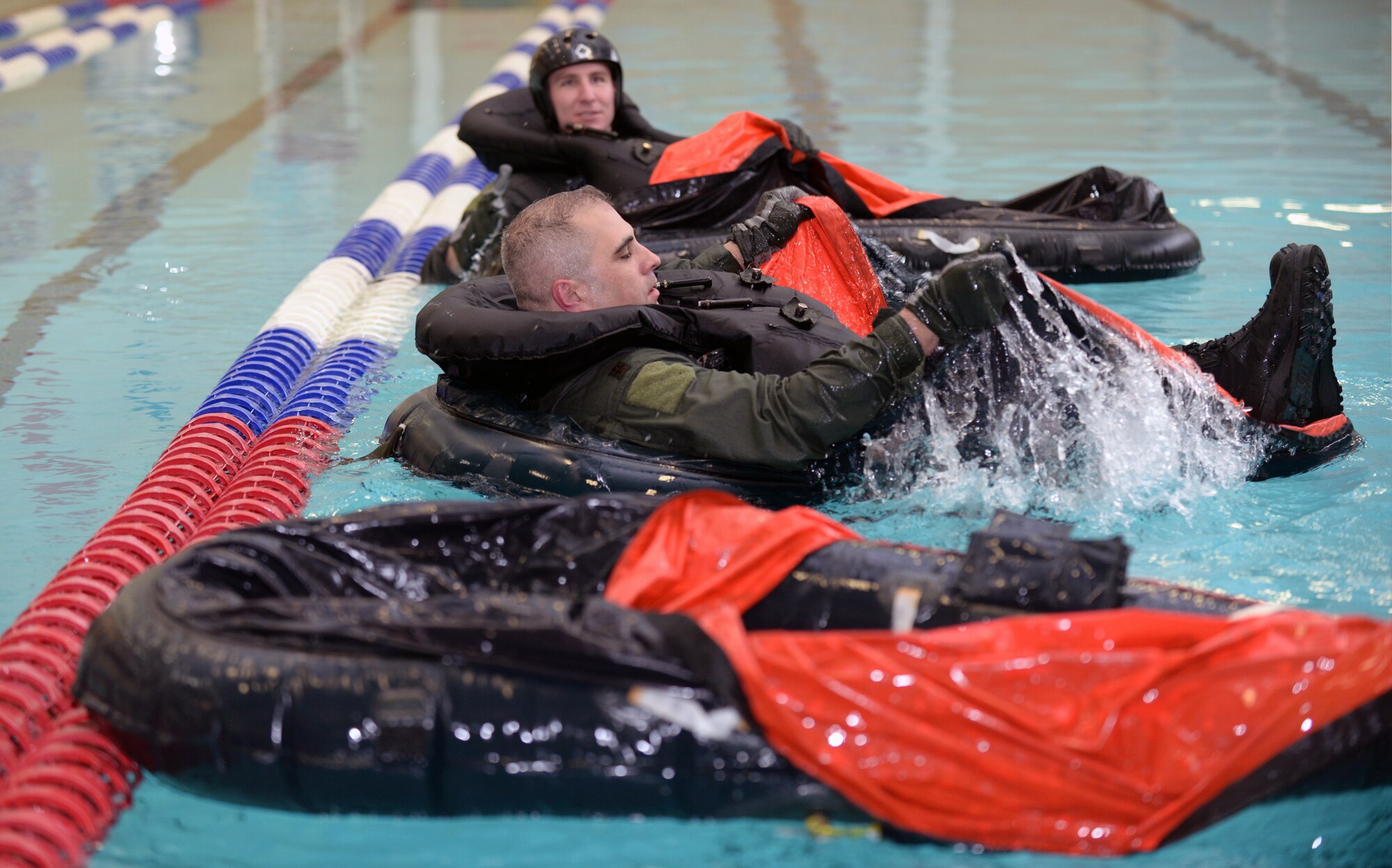 Maj. Daniel, 34th Bomb Squadron assistant director of operations, establishes himself in a deployable raft during Survival, Evasion, Resistance, and Escape training at the Bellamy Fitness Center indoor pool at Ellsworth Air Force Base, S.D., Feb. 9, 2016. Aircrew members learn various ways to mount the rafts depending on the situation in the event of emergency ejection over water, as well as how to establish themselves in the raft for long-term survival. (U.S. Air Force photo by Airman Donald C. Knechtel/Released)
