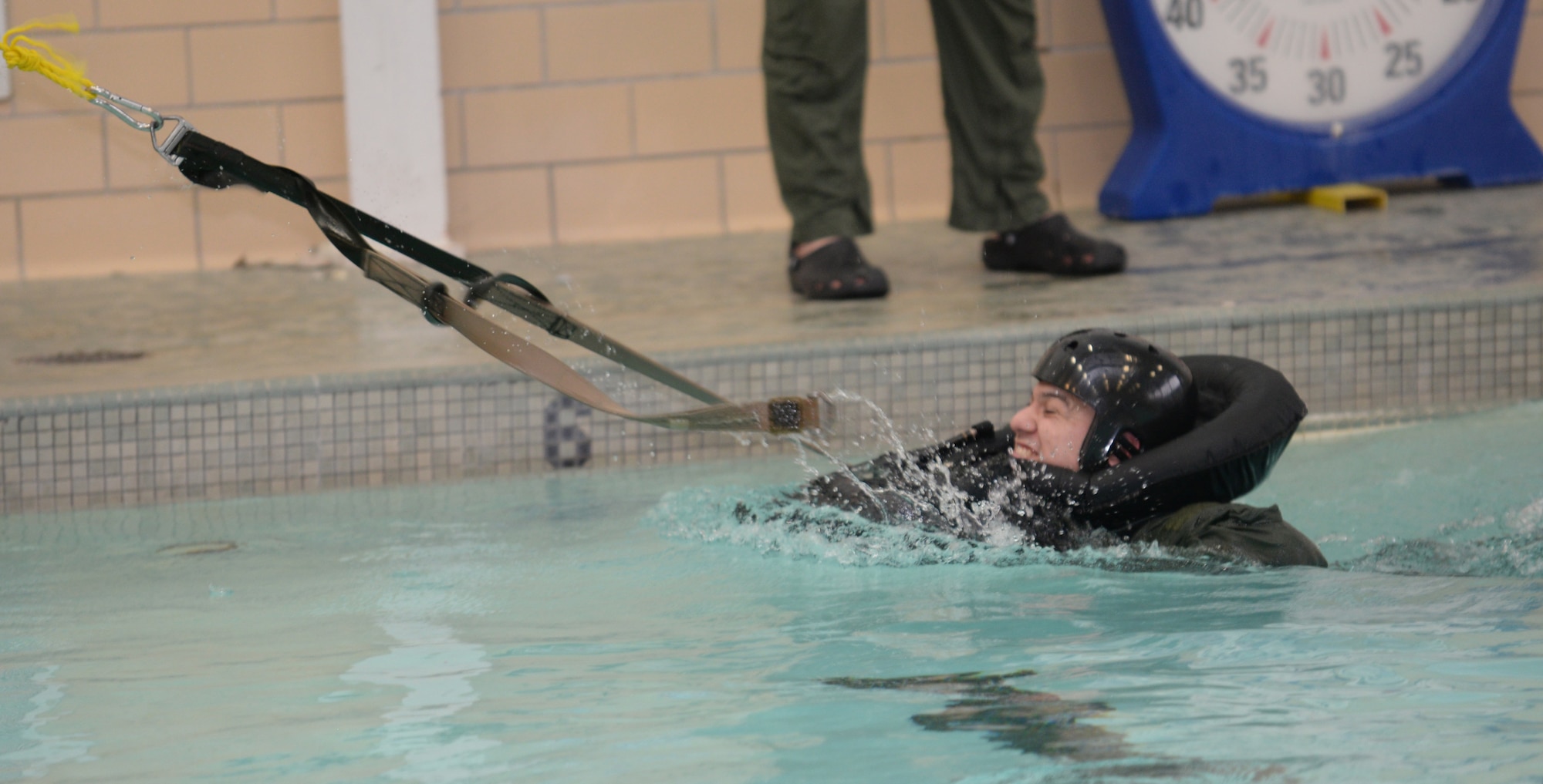 First Lt. Caesar, 34th Bomb Squadron weapon systems officer, undergoes parachute drag training at the Bellamy Fitness Center indoor pool at Ellsworth Air Force Base, S.D., Feb. 9, 2016. In order to fly on an aircraft, aircrew members must receive annual Survival, Evasion, Resistance, and Escape refresher training to keep their minds sharp and well prepared. This starts off with academics before moving on to hands-on training. (U.S. Air Force photo by Airman Donald C. Knechtel/Released)