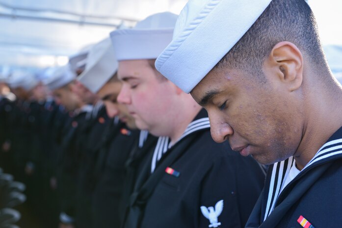 Sailors bow their heads in prayer during the graduation ceremony of Nuclear Power School class 1506 at Naval Nuclear Power Training Command (NNPTC) in Goose Creek, S.C. Based at Joint Base Charleston-Naval Weapons Station, NNPTC trains Sailors in fundamentals of design, operation, and maintenance of shipboard nuclear propulsion plants. (U.S. Navy Photo by Mass Communications Specialist Second Class Jason Pastrick)