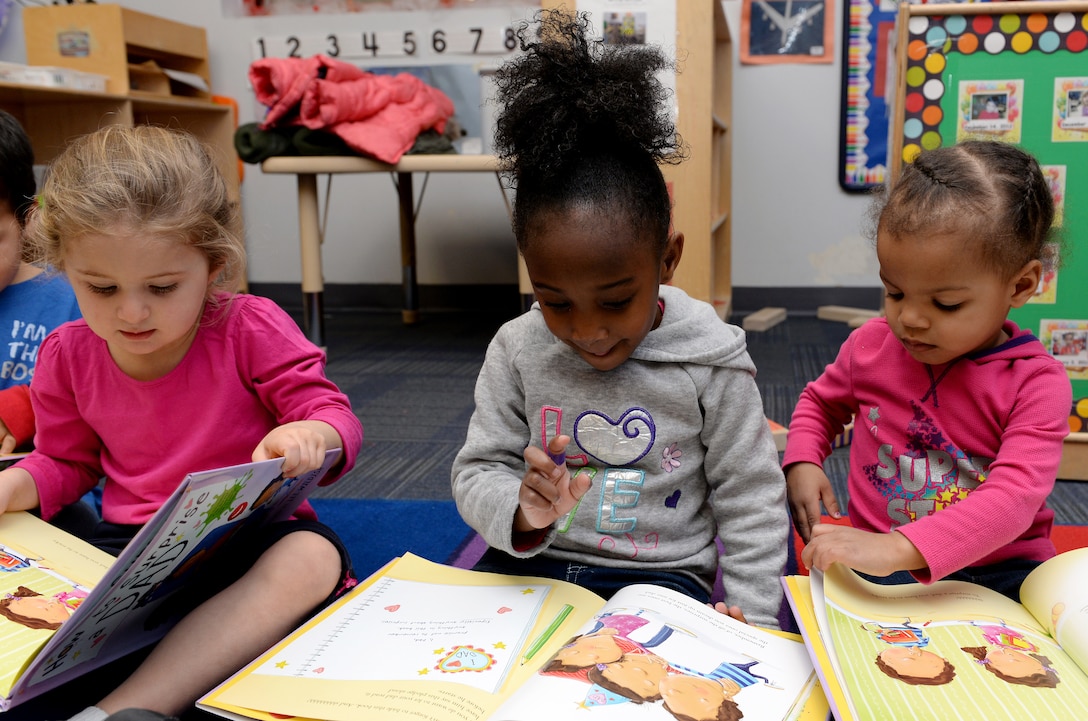 Three preschool students read books at the Child Development Center at Langley Air Force Base, Va., Feb. 16, 2016. The children received the books free of charge through The Mayor’s Book Club, which provides community members an opportunity to promote affection for reading to preschool children. (U.S. Air Force photo by Airman 1st Class Kaylee Dubois/Released)