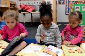 Three preschool students read books at the Child Development Center at Langley Air Force Base, Va., Feb. 16, 2016. The children received the books free of charge through The Mayor’s Book Club, which provides community members an opportunity to promote affection for reading to preschool children. (U.S. Air Force photo by Airman 1st Class Kaylee Dubois/Released)
