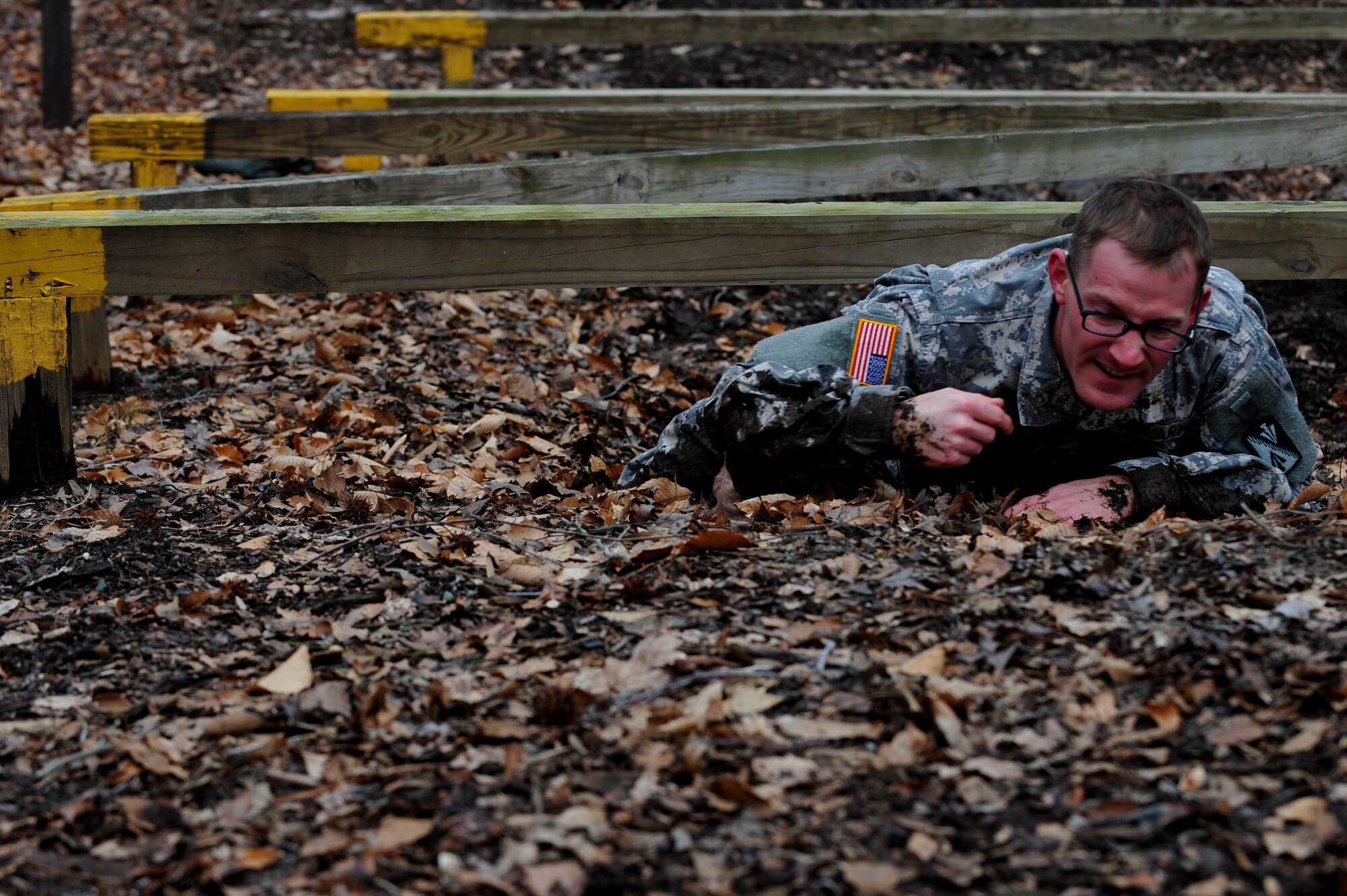A U.S. Army Soldier low crawls during the 128th Aviation Brigade Noncommissioned Officer of the Year and Platoon Sergeant of the Year Competition   obstacle course at Fort Eustis, Va., Feb. 25, 2016. Following the obstacle course, the competitors participated in 12-mile road march. (U.S. Air Force photo by Airman 1st Class Breonna Veal)