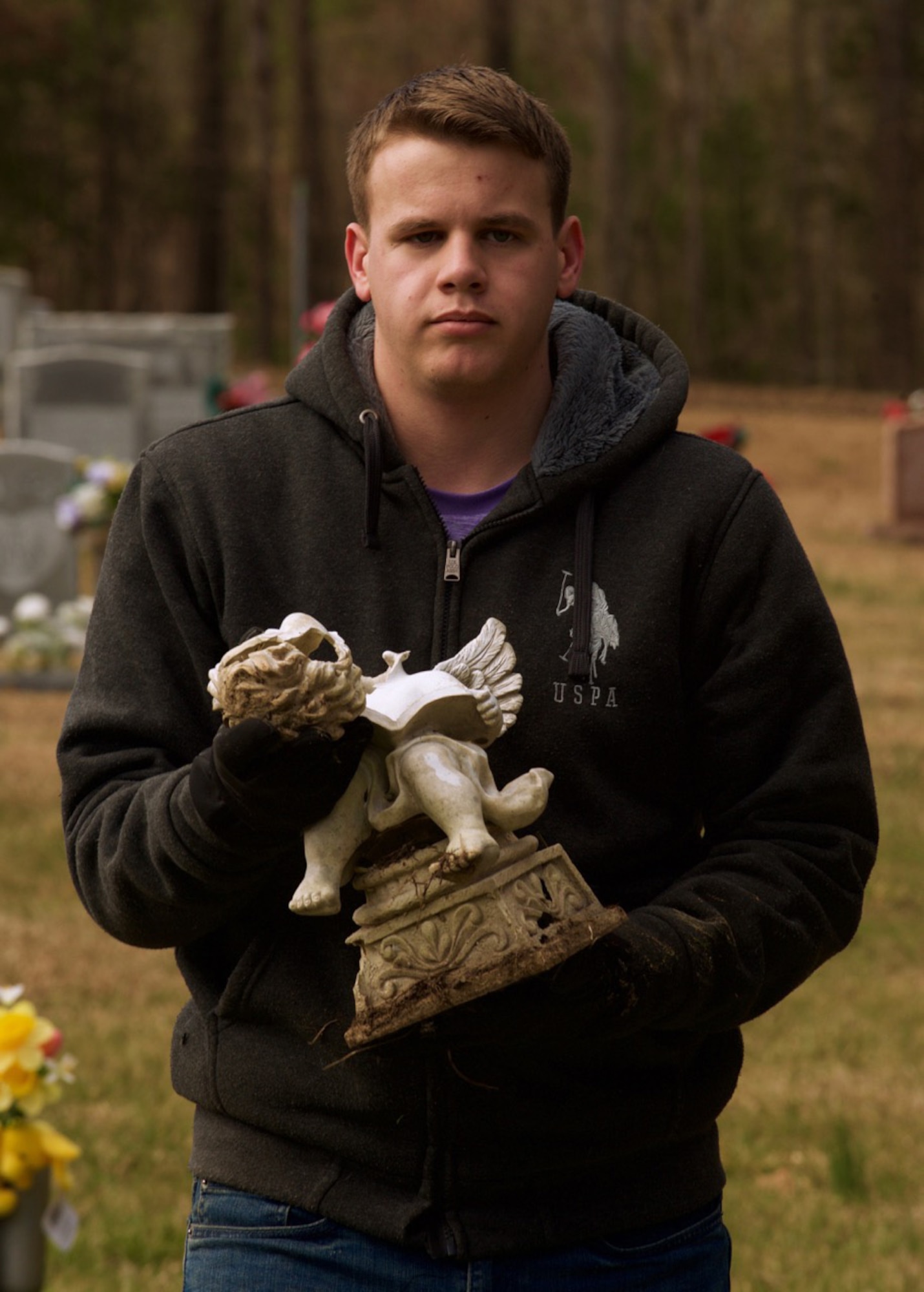 U.S. Air Force Airman 1st Class Anthony Vaughn, a knowledge operator assigned to the 633rd Communications Squadron at Langley Air Force Base, Va., carries broken pieces of a grave ornament at the Waverly Cemetery in Waverly, Virginia, Feb. 26, 2016. The volunteers lifted toppled headstones, cleared knocked over trees, and picked up debris throughout the cemetery. (U.S. Air Force photo by Staff Sgt. J.D. Strong II)