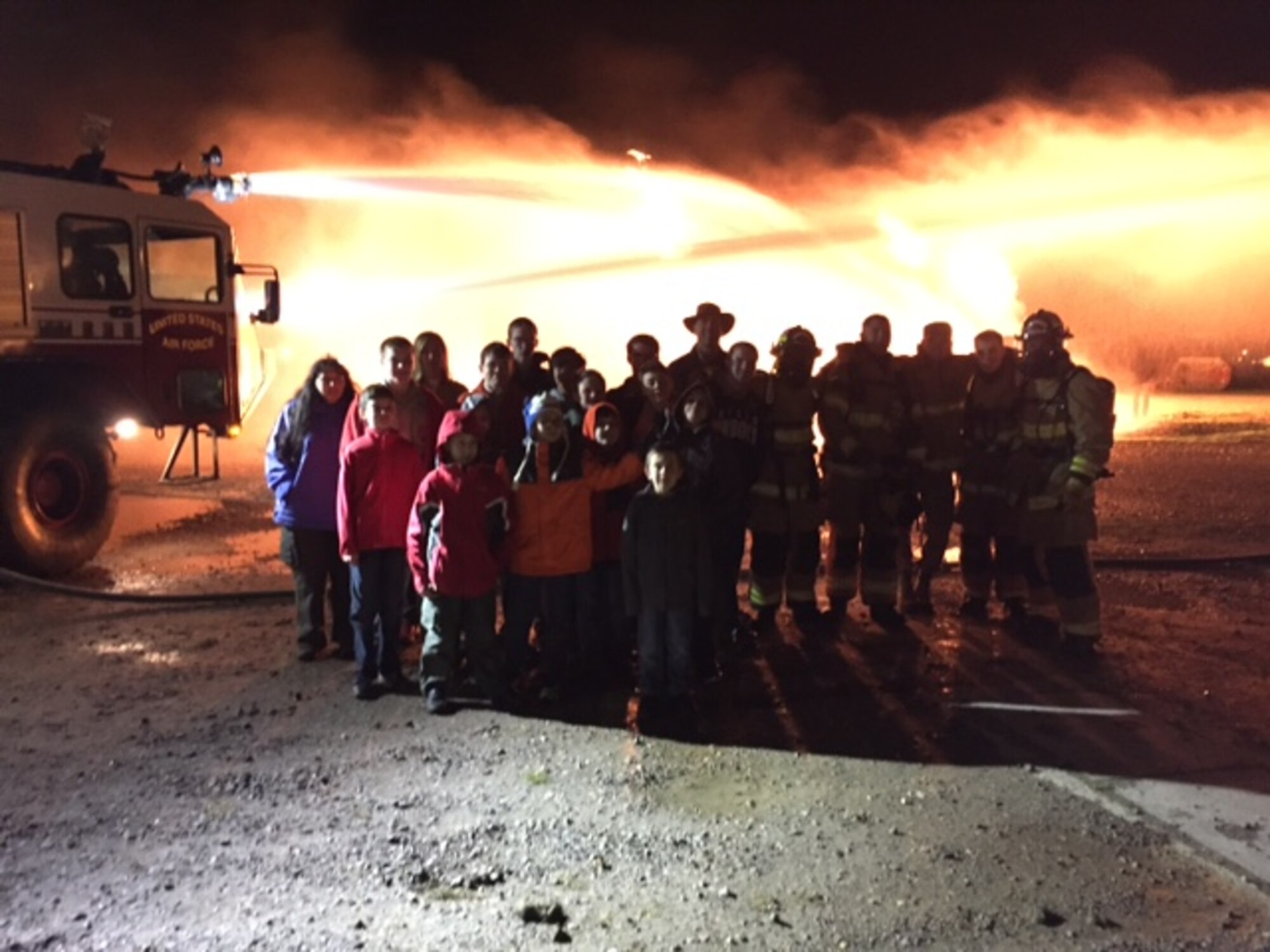 Boy Scouts of America and 100th Civil Engineer Squadron Fire Department firefighters post for a photograph following a live fire training session Jan. 13, 2016, on RAF Mildenhall, England. The children received training for their Boy Scouts of America Fire Safety Merit Badge program. (Courtesy photo/Released)