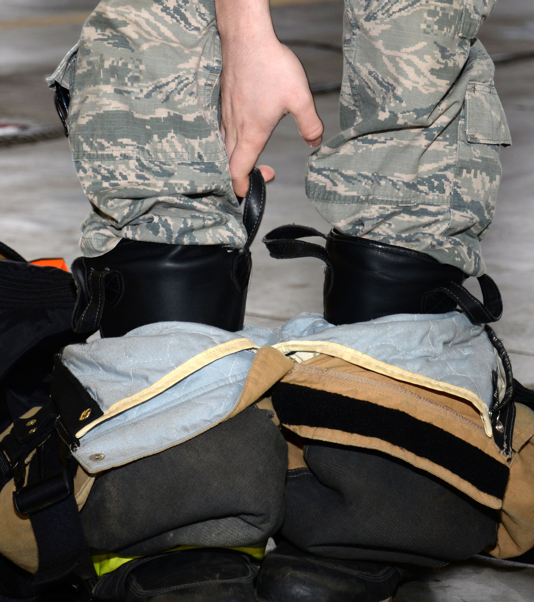 U.S. Air Force Senior Airman Conor Delaney, 100th Civil Engineer Squadron firefighter, practices changing into his safety gear quickly Feb. 22, 2016, on RAF Mildenhall, England. A firefighter must be ready to react at all times to save lives. (U.S. Air Force photo by Gina Randall/Released)