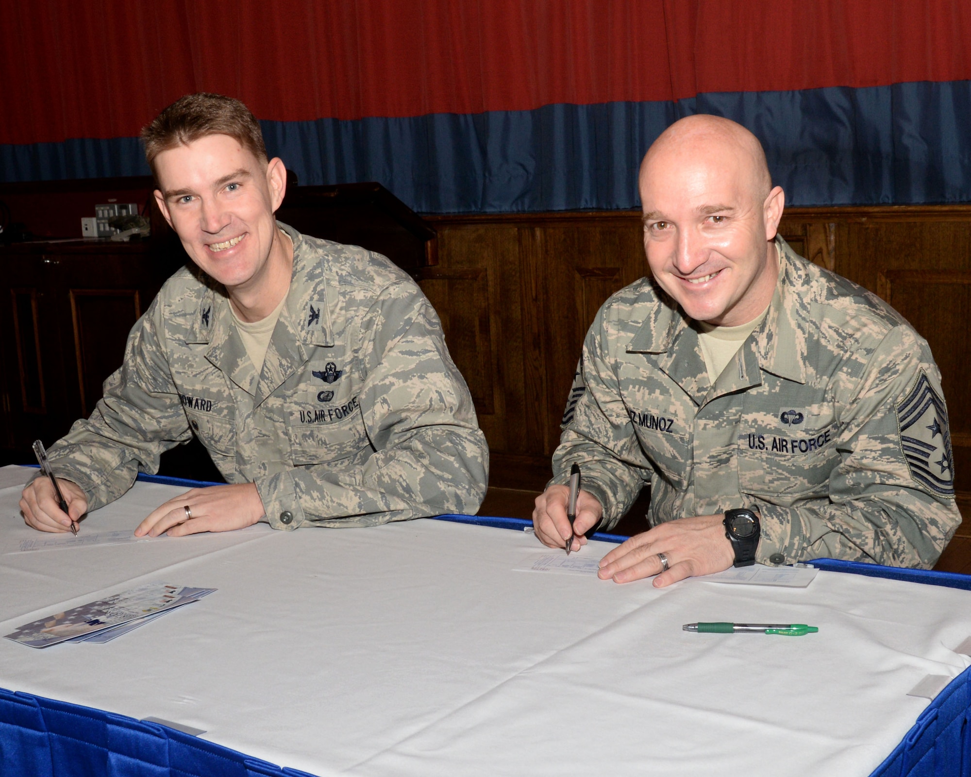 U.S. Air Force Col. John Howard, left, 100th Air Refueling Wing vice commander, and U.S. Air Force Chief Master Sgt. Anthony Cruz Munoz, 100th ARW command chief, pledge the first official donations to the 2016 Air Force Assistance Fund March 2, 2016, on RAF Mildenhall, England. The AFAF is an annual effort to raise funds for programs that provide support to Air Force families in times of need. These designated programs include the Air Force Aid Society, Air Force Villages Charitable Foundation, Air Force Enlisted Village and the General and Mrs. Curtis E. LeMay Foundation. (U.S. Air Force photo by Senior Airman Justine Rho/Released)