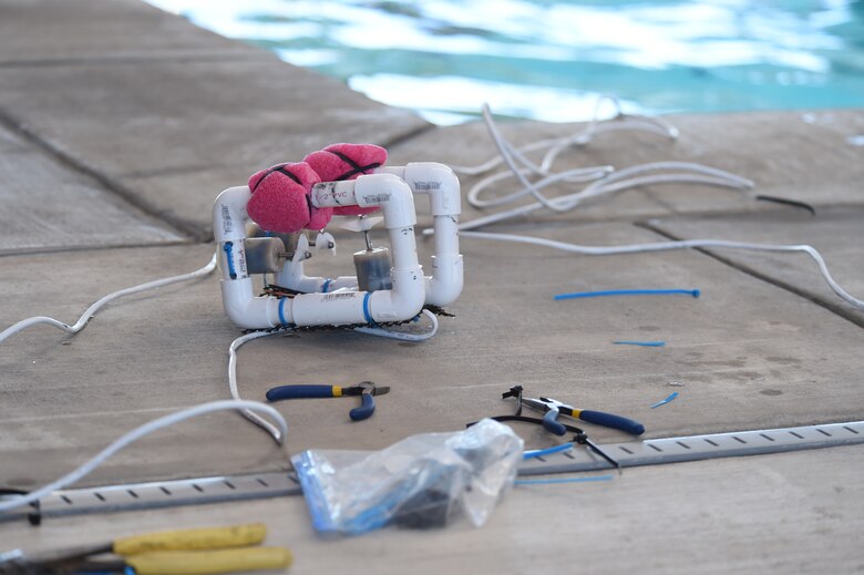 A SeaPerch remotely operated vehicle sits among tools and pieces of discarded zip ties by the Tierra Vista Community Center pool at Schriever Air Force Base, Colorado, following a practice session Friday, Feb. 26, 2016. The SeaPerch program helps students learn about science, technology, engineering and mathematics concepts through practical application. (U.S. Air Force photo/Staff Sgt. Debbie Lockhart)