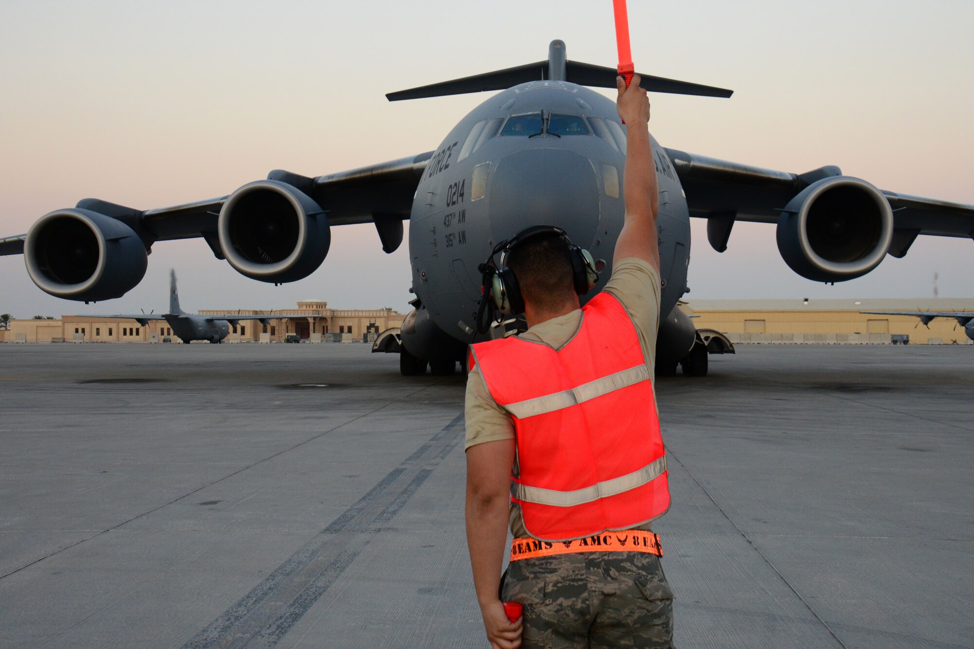 Airman 1st Class Jacob Chambers, 8th Expeditionary Air Mobility Squadron C-17 Globemaster III crew chief, from Natchitoches, La., marshals in a C-17 Globemaster III at Al Udeid Air Base, Qatar, Feb. 19. The 8th EAMS maintenance team performs maintenance actions on C-17 aircraft to ensure they’re mission ready. (U.S. Air Force photo by Tech. Sgt. James Hodgman/Released)