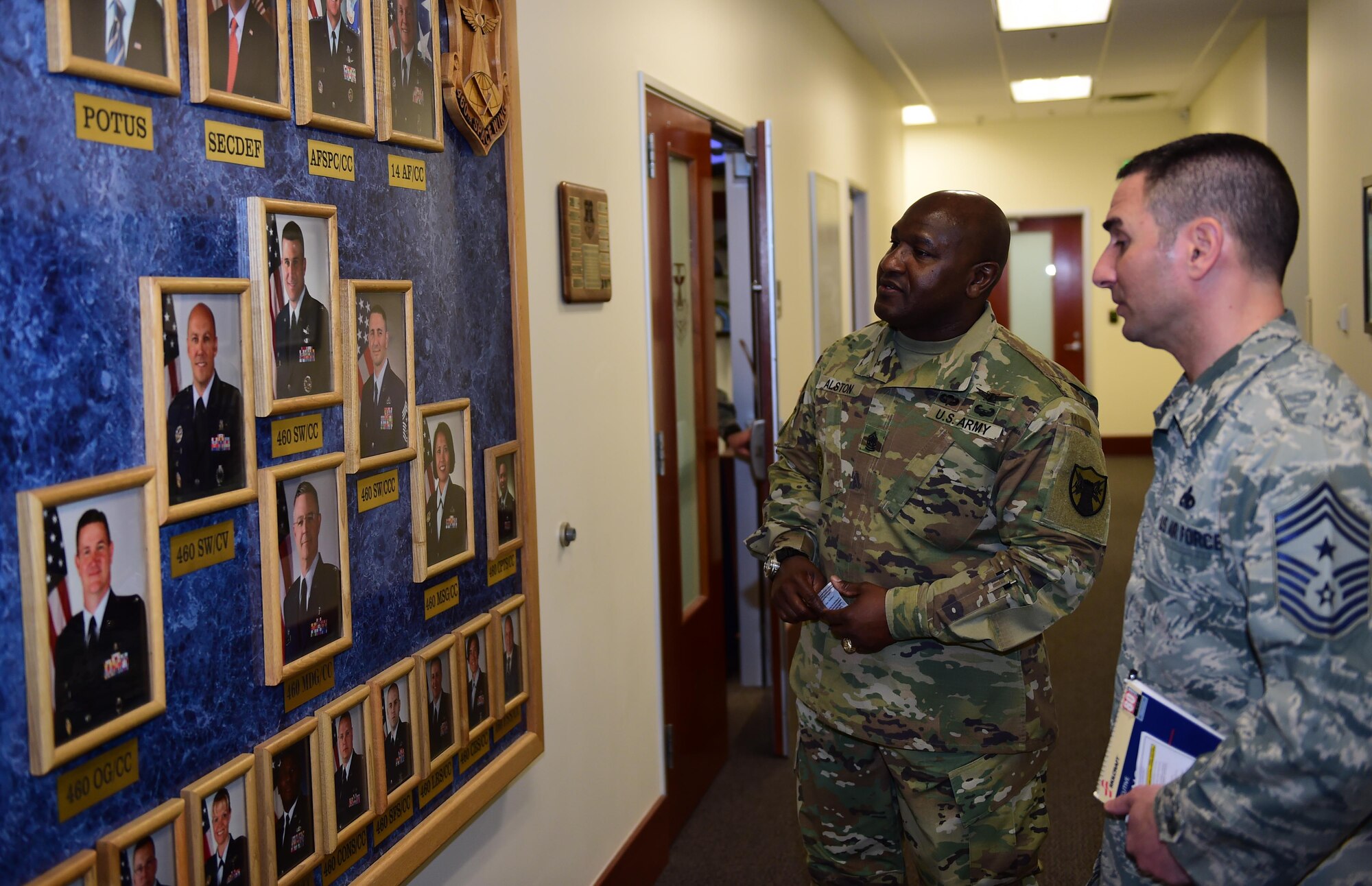 U.S. Army Command Sergeant Major Patrick Alston, United States Strategic Command senior enlisted leader, and U.S. Air Force Chief Master Sgt. Brian Kruzelnick, 460th Space Wing command chief, look over the 460th Space Wing leadership board during a base tour Feb. 26, 2016, at headquarters on Buckley Air Force Base, Colo. Alston spoke with Buckley Airmen about what it takes to be effective leaders. (U.S. Air Force photo by Airman 1st Class Gabrielle Spradling/Released) 