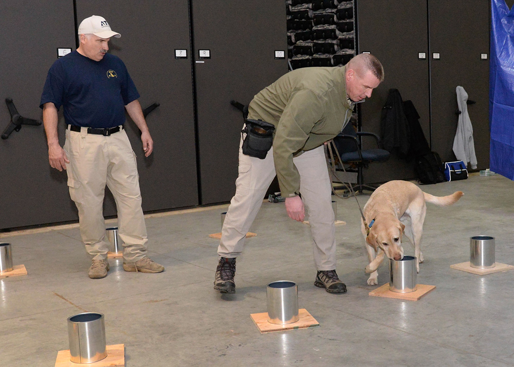 Massachusetts State Trooper Mike Rogowski and his dog, Jedi, practice for the National Odor Recognition Testing at Hanscom Air Force Base, Mass., March 2, while Keith Kopczynski, an instructor with the Bureau of Alcohol, Tobacco, Firearms and Explosives National Canine Division, looks on. The explosive detection training was provided by the ATF to 70 area canine teams from 14 different law enforcement agencies, including Airmen from the 66th Security Forces Squadron Military Working Dog section. (U.S. Air Force photo by Linda LaBonte Britt)