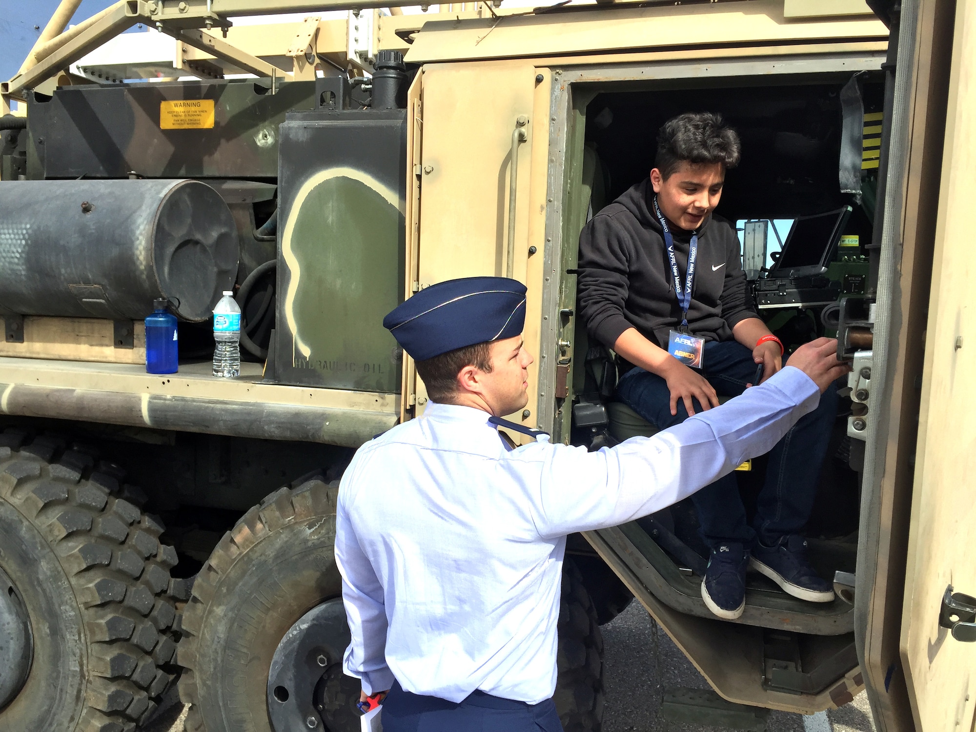 Air Force Research Laboratory New Mexico's 1st Lt. Kyle Ziegler shows Garfield Middle School student Abner Sapiens the Max Power vehicle and how AFRL uses Science, Technology, Engineering and Mathematics in their mission of research and development here March 1. The visit, which included groups from Garfield and Wilson Middle Schools, was part of the Day at the Lab event hosted by AFRL. National laboratories across the US are holding similar events this week as part of a White House initiative to encourage more children to become involved in STEM and to show the exciting and diverse workplace the national laboratories provide. Ziegler, who is the program manager for Space Electrical Technology at AFRL, took students through experiments and demonstrations of scientific phenomena that scientists and engineers encounter in the course of their work at AFRL. Students also saw exhibits and demonstrations in microwave energy, the Cold Atom Lab, MAX POWER, a vehicle using microwaves to safely destroy improvised explosive devices, and the Roll-Out Solar Array. (Air Force photo by Jim Fisher)  