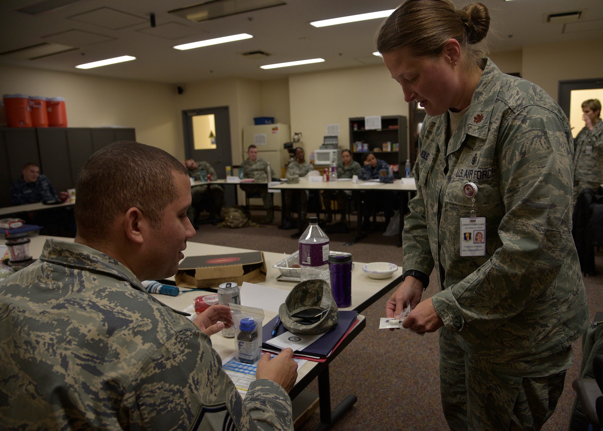 U.S. Air Force Maj. Nicole Molett, the emergency services flight commander of the 35th Medical Operations Squadron, right, shows Master Sgt. Jose Sanchez, the fire alarm systems NCO-in-charge with the 35th Civil Engineer Squadron, a toluidine blue dye sample during the victim advocates training at Misawa Air Base, Japan, Feb. 25, 2016. The dye is used during sexual assault medical exams, which can detect and document genital and perianal injuries after an attack. (U.S. Air Force photo by Senior Airman Deana Heitzman)