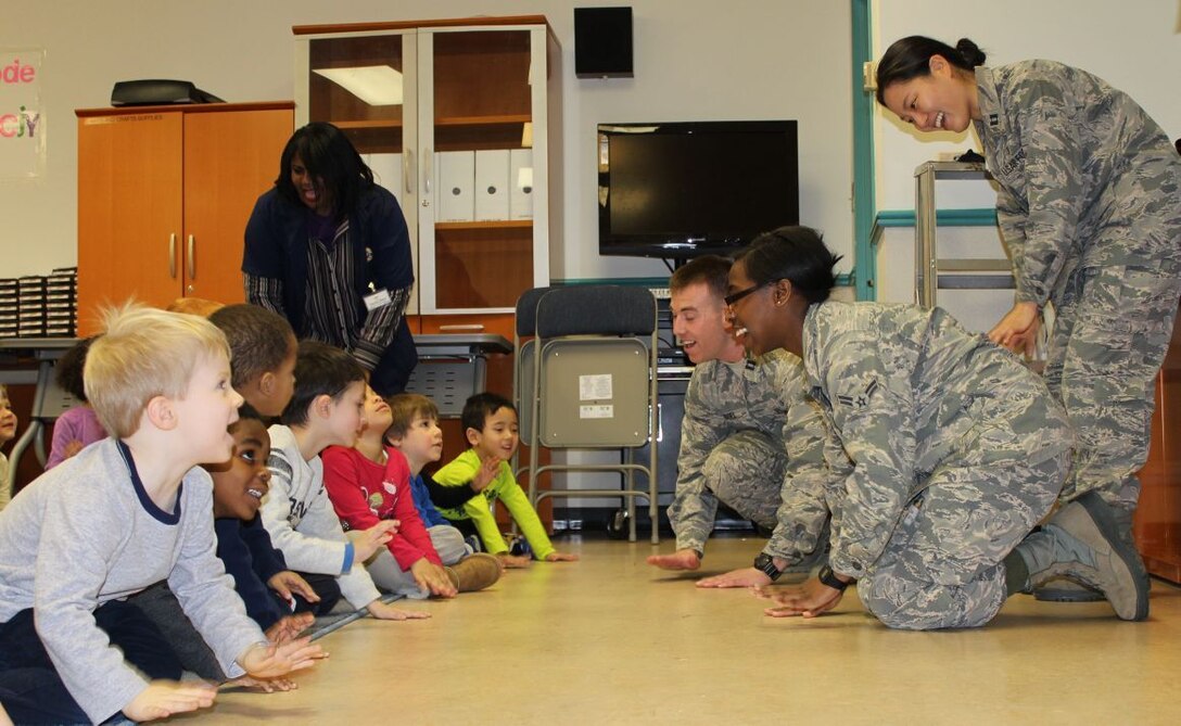 579th Dental Squadron's dental assistant Airman 1st Class Tanaja Jarrett; dental resident Capt. Tyler Vogel; and dental resident Capt. Jean Yoon, play a nutritional game with CDC 1 preschoolers in observance of National Children’s Dental Health Month in February. (U.S. Navy photo by Tamara Ward))