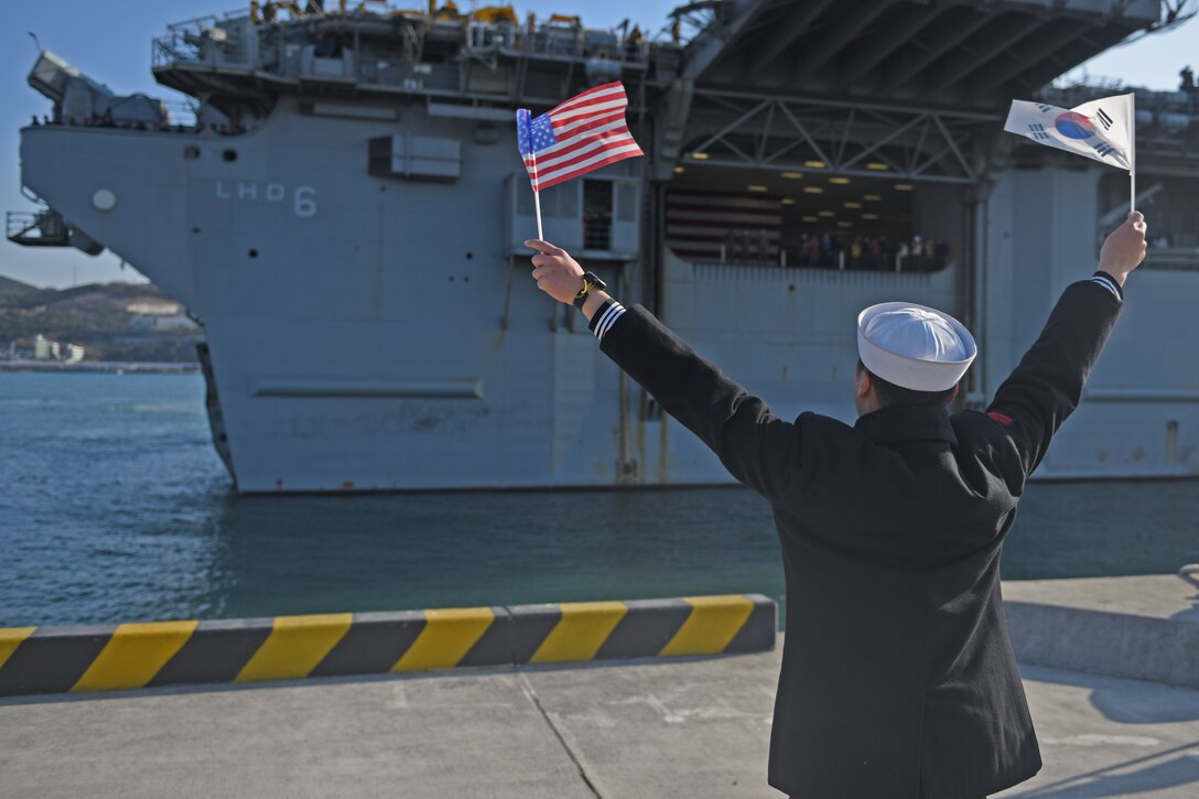 BUSAN, Republic of Korea (March 03, 2016) A Republic of Korea (ROK) Sailor waves the U.S. and ROK flags as USS Bonhomme Richard (LHD-6) pulls into ROK Fleet base. Bonhomme Richard is the flagship of the Bonhomme Richard Expeditionary Strike Group (ESG) 7 and is visiting Busan as part of a regularly scheduled port visit. (U.S. Navy photo by Mass Communications Specialist Jermaine M. Ralliford/RELEASED)