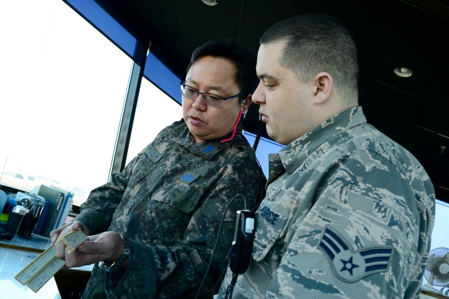 Republic of Korea air force Senior Master Sgt. No Jeong Park, 38th Fighter Group air traffic controller, explains to U.S. Air Force Senior Airman Joseph Shaffner, 8th Operations Support Squadron air traffic control journeyman, his portion of the job at Kunsan Air Base, Republic of Korea, Feb. 24, 2016. While working together as a unit is critical, they also realize that cooperation with other units make for a stronger force. (U.S. Air Force photo by Senior Airman Ashley L. Gardner/Released) 
