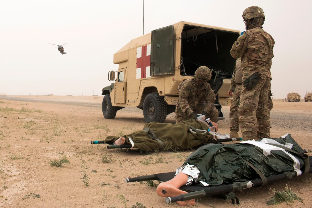 Soldiers prepare simulated casualties to be evacuated by an inbound UH-60 Black Hawk helicopter at a tactical combat casualty care lane at Camp Buehring, Kuwait, Feb. 23, 2016. Army photo by Staff Sgt. Ian M. Kummer