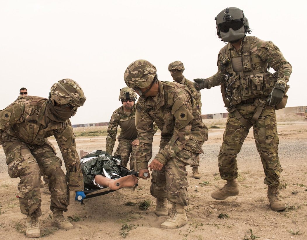 Army Sgt. Lopez, right, observes as soldiers transport a simulated casualty on a stretcher to be evacuated by a UH-60 Black Hawk helicopter at a tactical combat casualty care lane at Camp Buehring, Kuwait, Feb. 23, 2016. Lopez is a crew chief assigned to Company F, 2nd Battalion, 238th Aviation Regiment, 40th Combat Aviation Brigade. Army photo by Staff Sgt. Ian M. Kummer