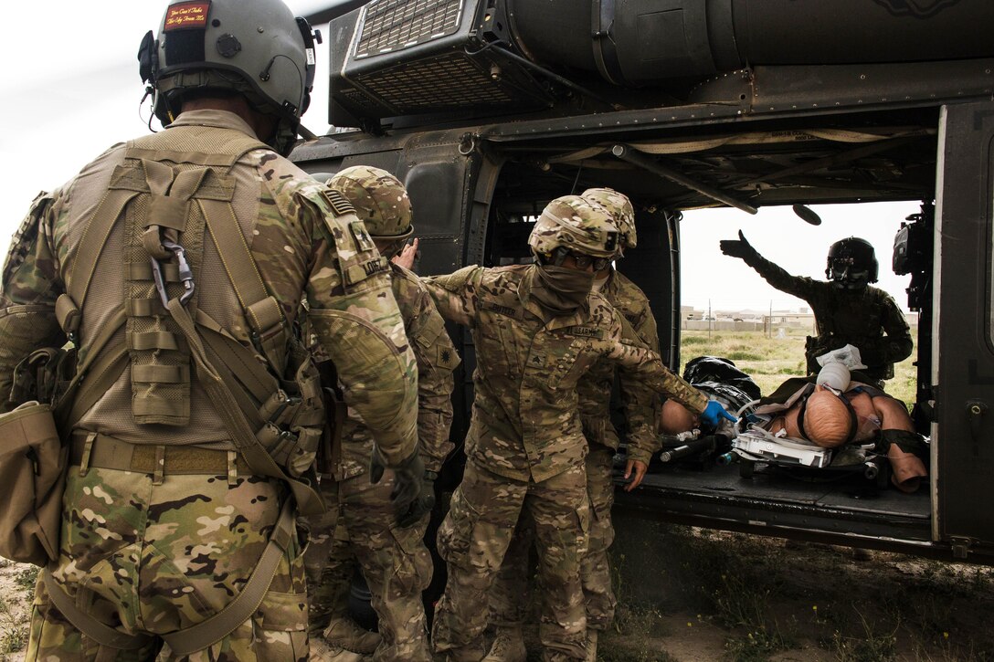 Soldiers carry a simulated casualty to be evacuated by a UH-60 Black Hawk helicopter at a tactical combat casualty care lane at Camp Buehring, Kuwait, Feb. 23, 2016. Army photo by Staff Sgt. Ian M. Kummer