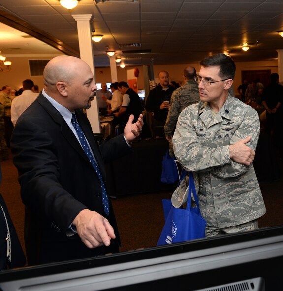 Russell Sarpy, law enforcement agent, speaks to Lt. Col. Hugh St. Martin, 2nd Communications Squadron commander, at the 4th Annual Technology Expo at Barksdale Air Force Base, La., Feb. 25, 2016. Sarpy has been part of an FBI task force which dismantled large scale organizations responsible for the influx of several thousand kilograms of cocaine in the Shreveport/Bossier City area, and he spoke about how a new program is putting criminals behind bars and can be incorporated for use at Barksdale. (U.S. Air Force photo/Airman 1st Class Curt Beach)