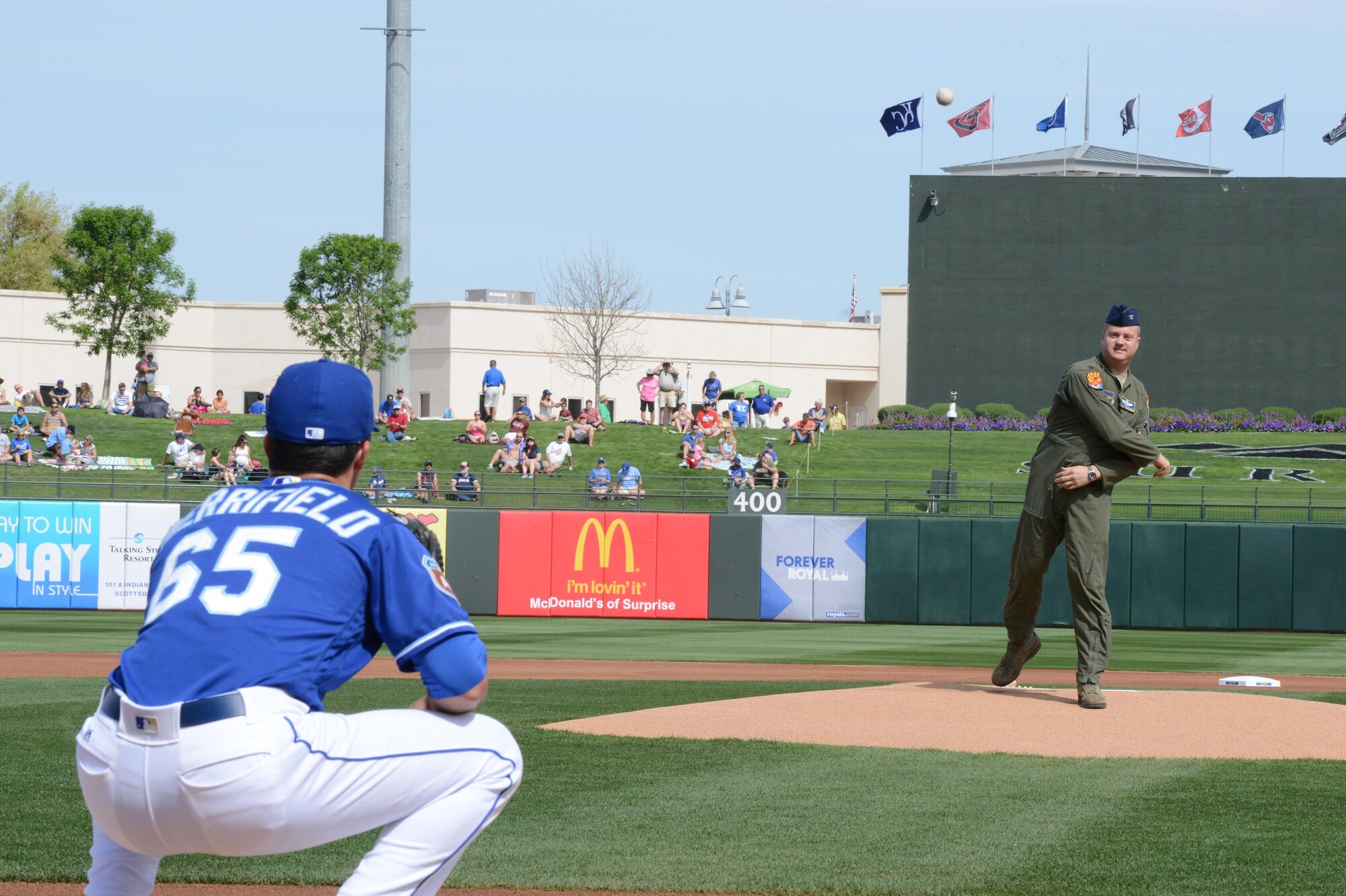 Col. David Shoemaker, 56th Fighter Wing vice commander, throws the first pitch of the game between the Kansas City Royals and the Texas Rangers to Whit Merrifield, Kansas City Royals left fielder, March 2, 2016 at Surprise Stadium. Several Major League Baseball teams come to Arizona for spring training including the Indians, Mariners, Padres, Rangers, Royals, Reds, Rockines, White Sox, Giants, Dodgers, Diamondbacks, Cubs, Brewers and the Athletics. 