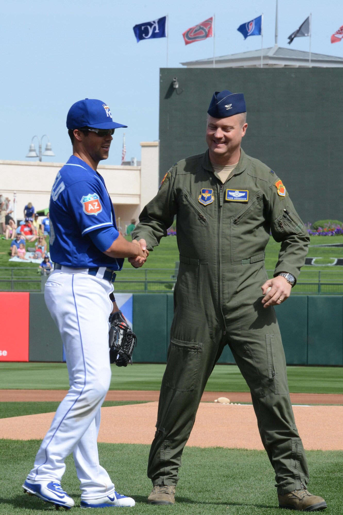 Col. David Shoemaker, 56th Fighter Wing vice commander, shakes hands with Whit Merrifield, Kansas City Royals left fielder, after throwing the first pitch starting the game between the Royals and the Texas Rangers March 2, 2016 at Surprise Stadium, Ariz. This was the start of the spring training for Major League Baseball teams. 
