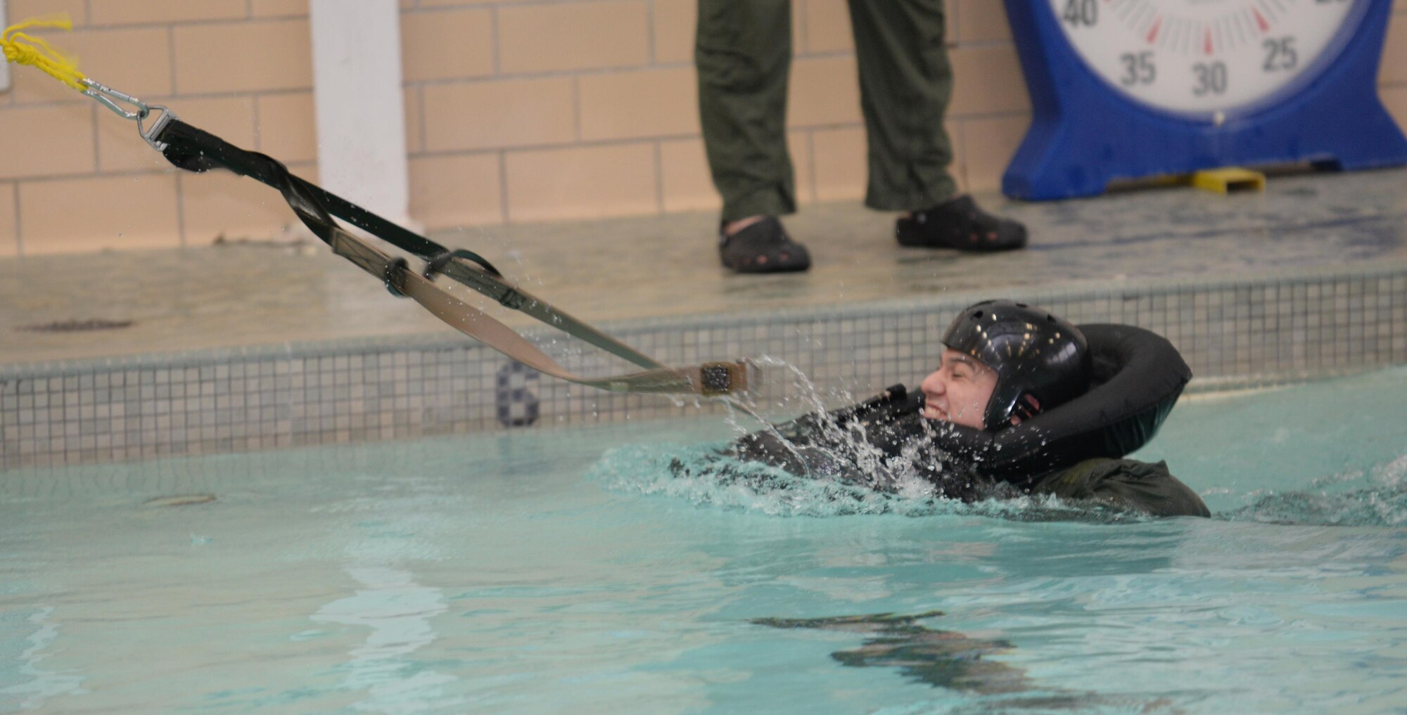 1st Lt. Caesar, 34th Bomb Squadron weapon systems officer, undergoes parachute drag training at the Bellamy Fitness Center indoor pool at Ellsworth Air Force Base, S.D., Feb. 9, 2016. In order to fly on an aircraft, aircrew members must receive annual Survival, Evasion, Resistance, and Escape refresher training to keep their minds sharp and well prepared. This starts off with academics before moving on to hands-on training. (U.S. Air Force photo by Airman Donald C. Knechtel/Released)