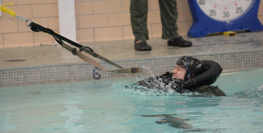 1st Lt. Caesar, 34th Bomb Squadron weapon systems officer, undergoes parachute drag training at the Bellamy Fitness Center indoor pool at Ellsworth Air Force Base, S.D., Feb. 9, 2016. In order to fly on an aircraft, aircrew members must receive annual Survival, Evasion, Resistance, and Escape refresher training to keep their minds sharp and well prepared. This starts off with academics before moving on to hands-on training. (U.S. Air Force photo by Airman Donald C. Knechtel/Released)