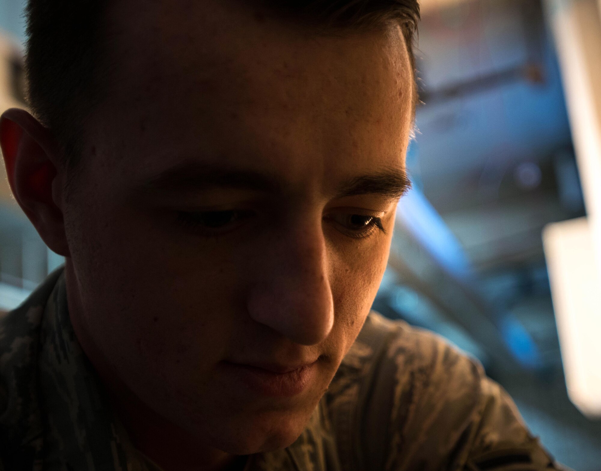 Airman 1st Class Joshua Sprinkles, a 354th Civil Engineer Squadron electrical technician, is shadowed by work lights while he roughs in wires during a remodel in Amber Hall on March 3, 2016, at Eielson Air Force Base, Alaska. With the lights off deep in the basement, the wiring is the ground work that will power office space to support missions across the U.S. Pacific Air Forces area of responsibility. (U.S. Air Force photo by Staff Sgt. Shawn Nickel/Released) 