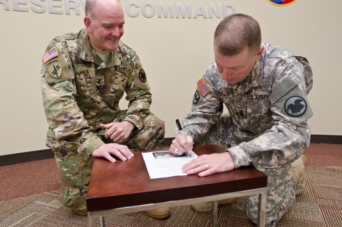 Command Sgt. Maj. Jim Wills, U.S. Army Reserve Command sergeant major, and Col. Alan Pomaville, USARC Command chaplain, sign the "Shoulder-to-Shoulder" pledge and suicide prevention initiative, at USARC headquarters, Fort Bragg, N.C., March 2, 2016. "Shoulder-to-Shoulder" is an initiative where each USAR Command Team can help protect the life of every Soldier in their unit, creating and continually reinforcing a blueprint of personal connections whereby Soldiers and their family members can easily reach out for help. (U.S. Army Reserve photo by Brian Godette, USARC Public Affairs)