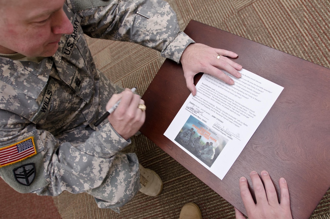 Command Sgt. Maj. Jim Wills, U.S. Army Reserve Command sergeant major, and Col. Alan Pomaville, USARC Command chaplain, sign the "Shoulder-to-Shoulder" pledge and suicide prevention initiative, at USARC headquarters, Fort Bragg, N.C., March 2, 2016. "Shoulder-to-Shoulder" is an initiative where each USAR Command Team can help protect the life of every Soldier in their unit, creating and continually reinforcing a blueprint of personal connections whereby Soldiers and their family members can easily reach out for help. (U.S. Army Reserve photo by  Brian Godette, USARC Public Affairs)