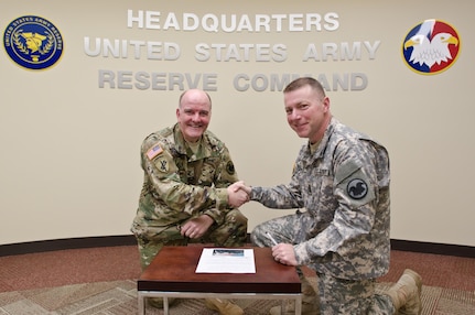 Command Sgt. Maj. Jim Wills, U.S. Army Reserve Command sergeant major, and Col. Alan Pomaville, USARC Command chaplain, sign the "Shoulder-to-Shoulder" pledge and suicide prevention initiative, at USARC headquarters, Fort Bragg, N.C., March 2, 2016. "Shoulder-to-Shoulder" is an initiative where each USAR Command Team can help protect the life of every Soldier in their unit, creating and continually reinforcing a blueprint of personal connections whereby Soldiers and their family members can easily reach out for help. (U.S. Army Reserve photo by  Brian Godette, USARC Public Affairs)