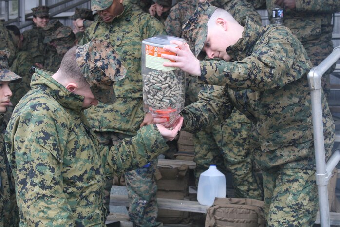 Marines with Headquarters and Service Battalion receive ear protection prior to a weapons familiarization live fire event.