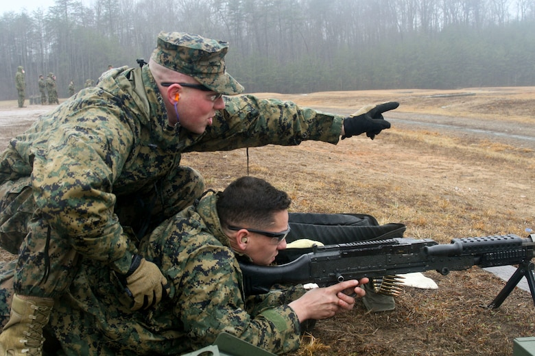 Gunnery Sgt. Antonio Alongi, a position safety officer, coaches a Marine firing an M240 machine gun.