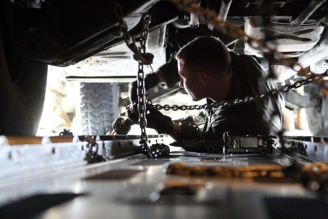 Staff Sgt. Jeremiah Gaulitz secures a Humvee to the deck of a KC-130J Super Hercules during cargo transportation for exercise Eager Response at Marine Corps Air Station Cherry Point, N.C., Feb. 24, 2016.  During the exercise, Marines trained in events such as casualty evacuation, assault support missions and aerial refueling, proving the 2nd Marine Aircraft Wing is a highly effective combat force. Gaulitz is a crew master with VMGR-252. (U.S. Marine Corps photo by Cpl. N.W. Huertas/ Released)