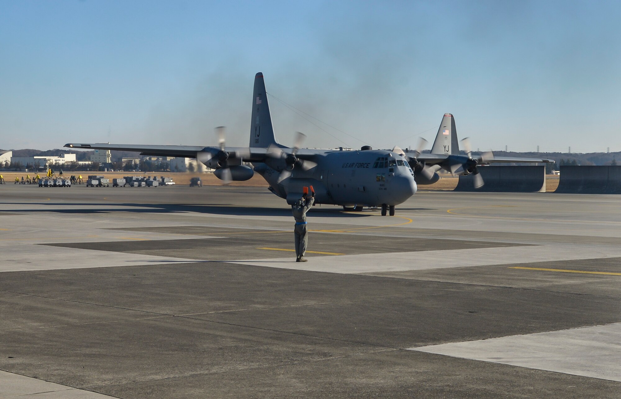 A 374th Aircraft Maintenance Squadron crew chief marshals a C-130 Hercules at Yokota Air Base, Japan, March 2, 2016. The 36th Airlift Squadron regularly conducts training missions to remain proficient in the necessary skills to support any contingency. (U.S. Air Force photo by Senior Airman David Owsianka/Released)