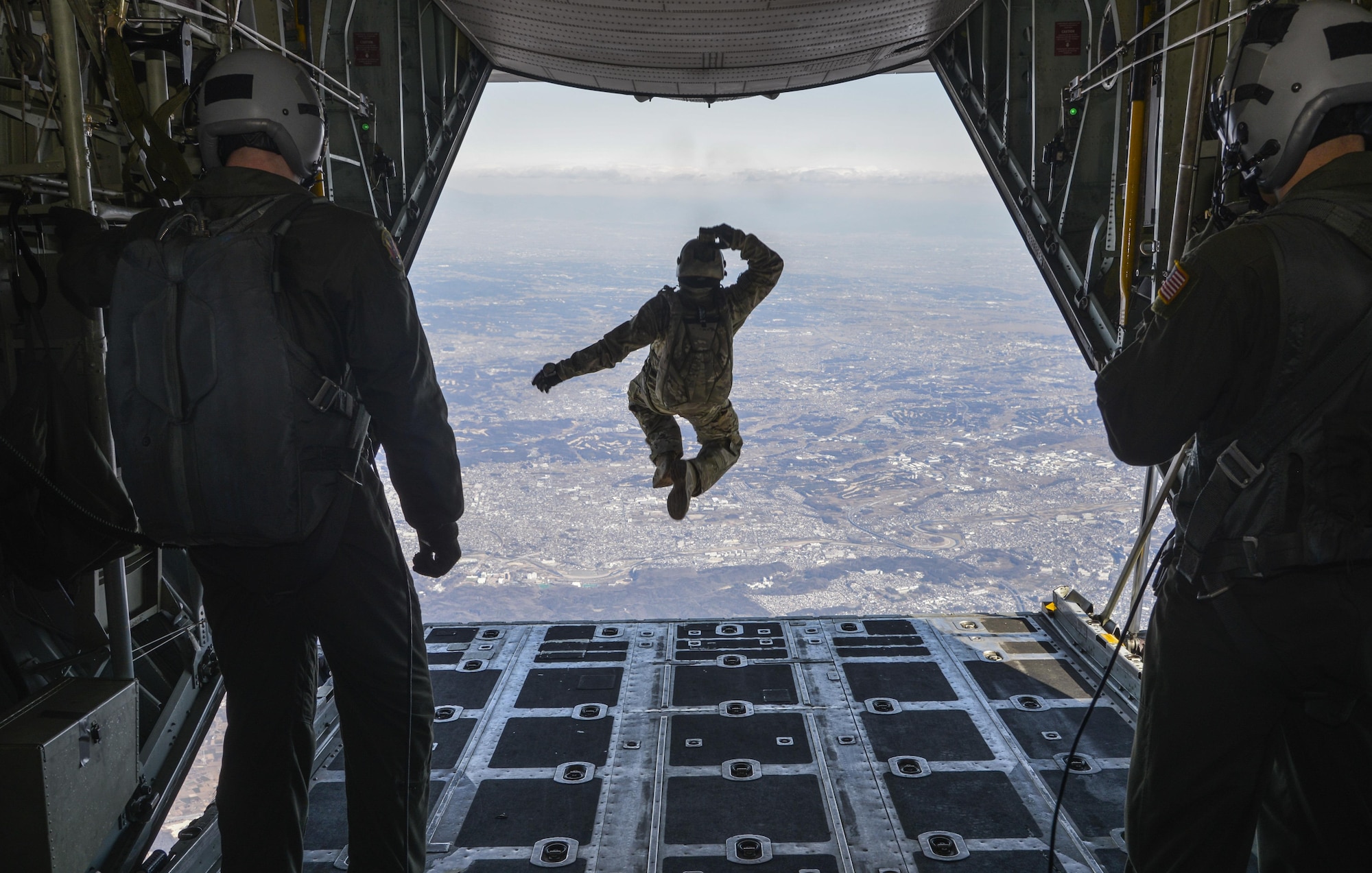 Tech. Sgt. Benjamin Jonas, 374th Operations Support Squadron survival, evasion, resistance and escape operations NCO in charge, jumps out of a C-130 Hercules while flying over Yokota Air Base, Japan, March 2, 2016. During the high-altitude, low-opening airdrop, Jonas jumped from 10,000 feet in the air and parachuted to the base. (U.S. Air Force photo by Senior Airman David Owsianka/Released)