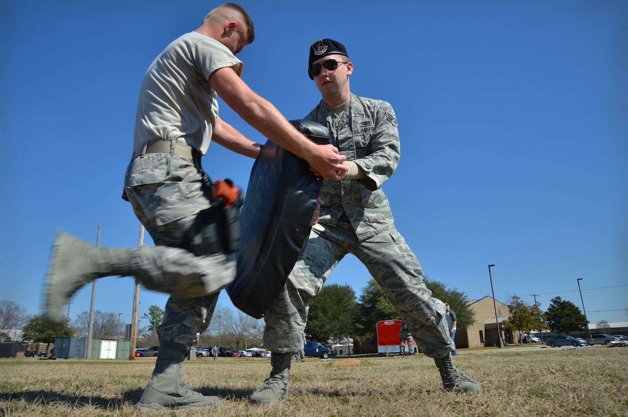 U.S. Air Force Airman 1st Class Joshua Beaugrand, 20th Security Forces Squadron entry controller, knees a strike pad after being pepper sprayed at Shaw Air Force Base, S.C., Feb. 29, 2016. The pepper spray training tests the Airmen to see how they would react in the event they get pepper sprayed while performing entry control duties. (U.S. Air Force photo by Senior Airman Michael Cossaboom)