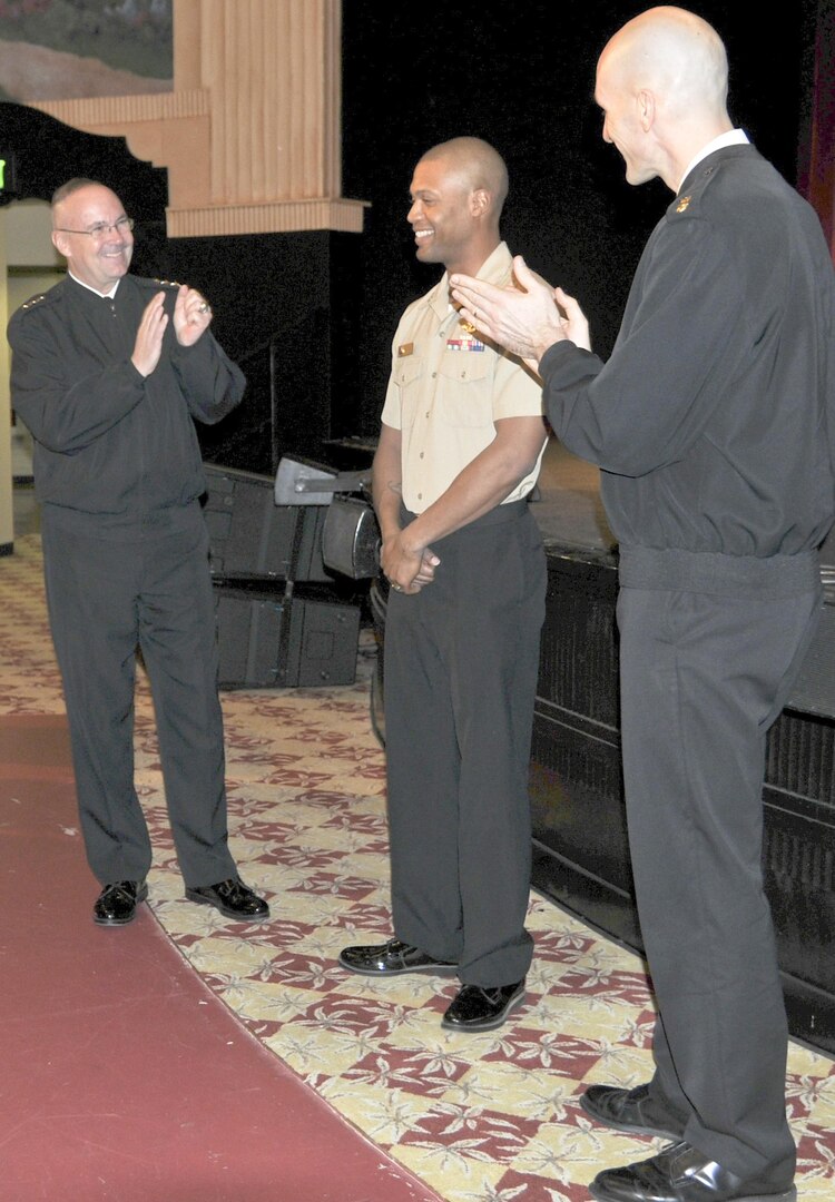SAN ANTONIO (Feb. 18, 2016) Vice Adm. C. Forrest Faison III, left, Navy Surgeon General and Chief, Bureau of Medicine and Surgery (BUMED), and BUMED Force Master Chief Terry Prince, right, applaud following the announcement of the achievements of Hospital Corpsman 2nd Class Brandon Ponder, center, since he checked on board Navy Medicine Education and Training Command (NMETC). Faison presented Ponder with a coin as congratualtions during an all hands call on board Joint Base San Antonio - Fort Sam Houston, Texas. (U.S. Navy photo by Mass Communication Specialist 1st Class Jacquelyn D. Childs/Released)