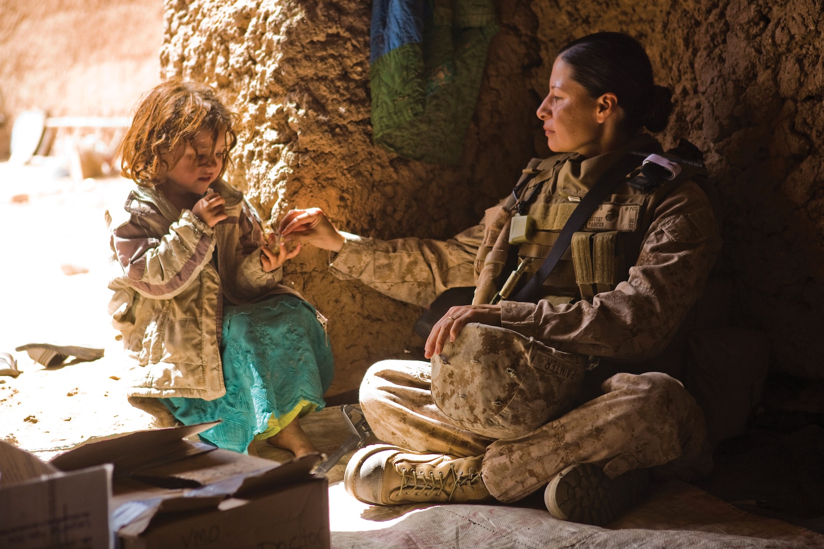 Member of a U.S. Marine Corps Female Engagement Team watches over an Afghan girl while the girl’s
mother receives medical attention from another team member.