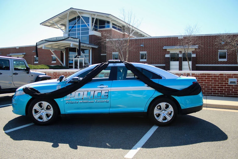 A police cruiser draped in black ribbon at the Prince William police western district station. 