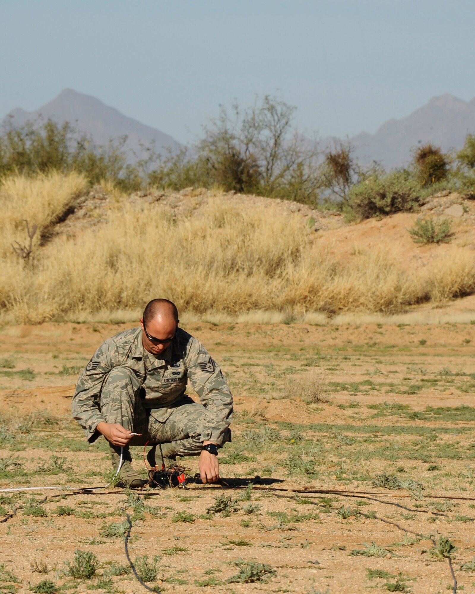 U.S. Air Force Staff Sgt. Patrick Barbarino, 355th Civil Engineer Squadron explosive ordnance disposal technician, prepares the firing point for a simulated bombing run detonation at Davis-Monthan Air Force Base, Ariz., Feb. 18, 2016. The EOD flight practiced for the demonstration they will display at the upcoming 2016 Thunder and Lighting over Arizona open house.  (U.S. Air Force photo by Airman 1st Class Mya M. Crosby/Released)